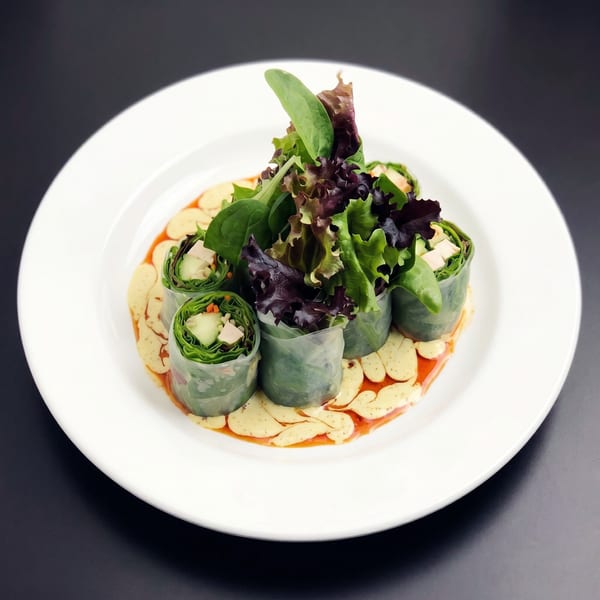 Fresh spring rolls with chicken, cucumber, and carrots, served with peanut and chili sauce.